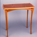 Mahogany Side Table: 1988 Mahogany, Quilted Mahogany Veneer, Ebony Stringing 28” tall, 29” wide, 17” deep $950